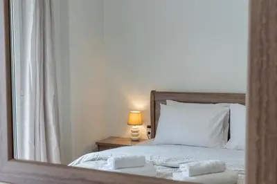 a bedroom with a bed with a mirror and a lamp at Comfy Sweet Home in Athens