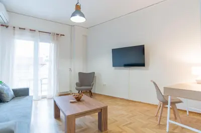 a living room with a table and a tv at Comfy Sweet Home in Athens
