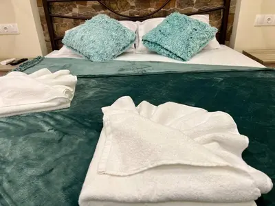 a bed with white sheets and blue pillows on it at Cute Corner In The Centre VIPGreece in Athens