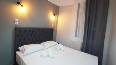 a bedroom with a bed with white sheets and pillows at Athens City Themis 14 in Athens