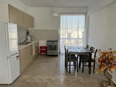 a kitchen with a table and a kitchen with a refrigerator at Kali - Thea Spacious 2 BR Penthouse, City View in Athens