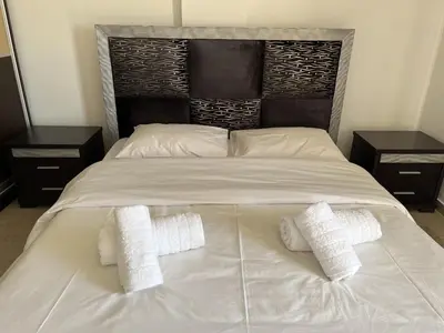 a large white bed with two pillows and two night stands at Kali - Thea Spacious 2 BR Penthouse, City View in Athens