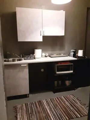 a kitchen with white cabinets and a sink and a stove at Athens Mets-Central apt in Athens