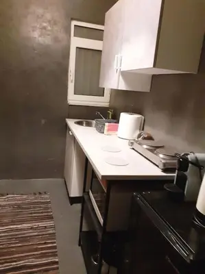 a kitchen with white cabinets and a counter top at Athens Mets-Central apt in Athens
