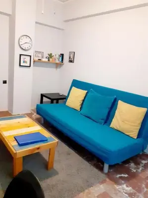 a blue couch in a living room with a table at Athens Mets-Central apt in Athens