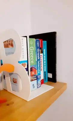 a book shelf with three books on it at Athens Mets-Central apt in Athens