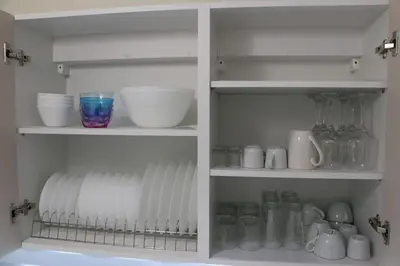 a white pantry with dishes and cups and mugs at Glyfada Path of Poets in Athens