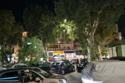 a group of cars parked in a parking lot with trees at Glyfada Path of Poets in Athens
