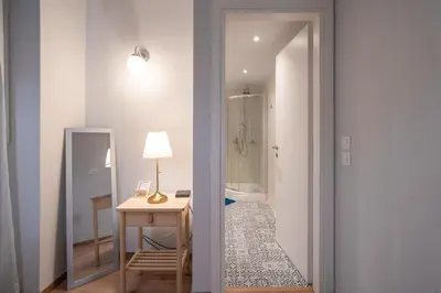 a room with a bed and a table and a mirror at Exclusive apartment in the heart of Athens in Athens