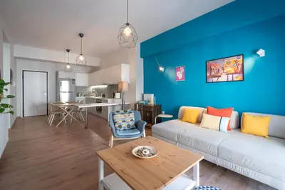 a living room with a white couch and a blue wall at Exclusive apartment in the heart of Athens in Athens