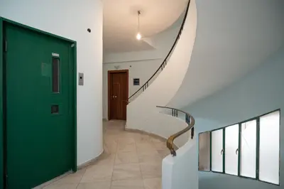 a hallway with a green door and a staircase at Exclusive apartment in the heart of Athens in Athens