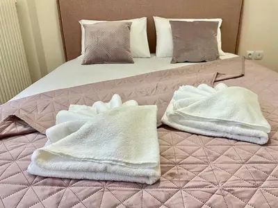 two white towels sitting on top of a bed at Cute Nikis Apartment VIPGreece in Athens