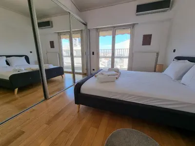 a large bedroom with two beds and a mirror at Luxury Living Athens by YHA in Athens