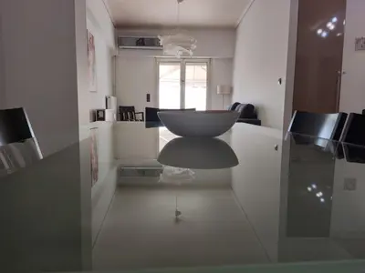 a white kitchen with a table and a chair at Luxury Living Athens by YHA in Athens