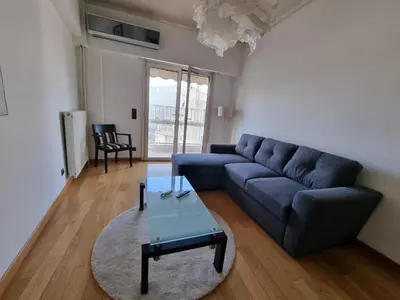 a living room with a blue couch and a table at Luxury Living Athens by YHA in Athens
