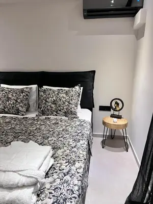 a bedroom with a bed and a side table at Lagonisi Luxury Apartment by the sea in Lagonissi