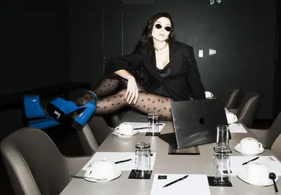 a woman sitting on a table in front of a laptop at NYX Esperia Palace Hotel Athens by Leonardo Hotels in Athens