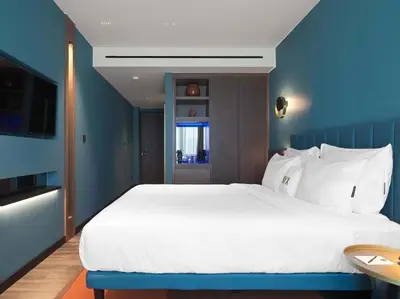 a bedroom with a large white bed with blue walls at NYX Esperia Palace Hotel Athens by Leonardo Hotels in Athens