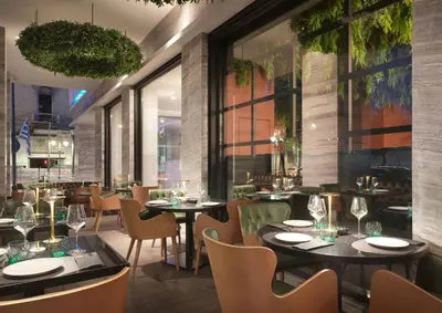 a restaurant with tables and chairs and windows at NYX Esperia Palace Hotel Athens by Leonardo Hotels in Athens