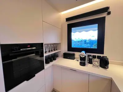 a kitchen with a flat screen tv on the wall at Lagonisi 2 bedroom luxury Apartment by the sea! in Lagonissi