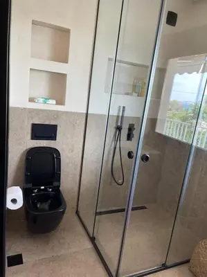 a bathroom with a toilet and a glass shower at Lagonisi Luxury apartment 2 by the sea in Lagonissi