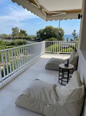 a porch with pillows and a table on a balcony at Lagonisi Luxury apartment 2 by the sea in Lagonissi