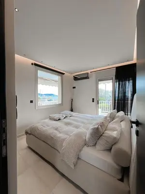 a white bedroom with a large bed with pillows at Lagonisi Luxury apartment 2 by the sea in Lagonissi