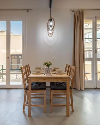 a dining room table and chairs with a table and a window at Christiana's lovely apartment in Psyri, Athens in Athens