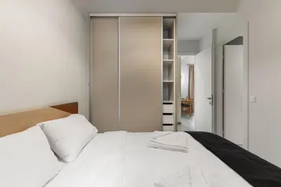 a bedroom with a white bed and a closet at Christiana's lovely apartment in Psyri, Athens in Athens