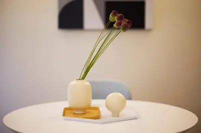 a white vase with a flower in it on a table at Phaedrus Living Kolonaki Crown Residences in Athens