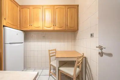 a small kitchen with a table and a refrigerator at Athens City Getaway in Athens