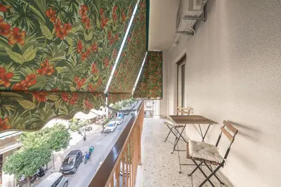 a balcony with a table and chairs and a mural at Athens City Getaway in Athens
