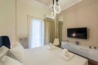 a white bedroom with a large bed with two towels at MEDLUXE COZY APARTMENT! in Athens