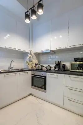 a white kitchen with white cabinets and appliances at MEDLUXE COZY APARTMENT! in Athens