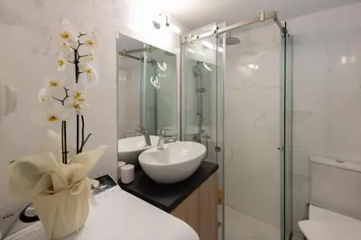 a bathroom with a sink and a glass shower at MEDLUXE COZY APARTMENT! in Athens