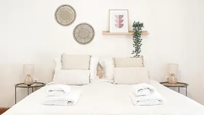 a white bedroom with a white bed with towels on it at Boho Chic 2BR Apartment in the Center of Athens in Athens
