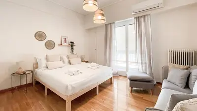 a white bedroom with a bed and a couch at Boho Chic 2BR Apartment in the Center of Athens in Athens