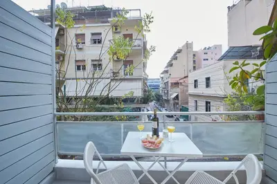a white table and chairs on a balcony with a view at Artemis Suite at Acropolis Historic Center in Athens