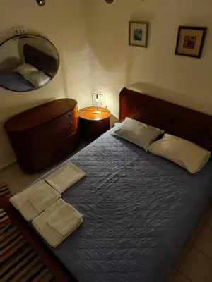a bedroom with a bed and a mirror and a table at Friends Apartment Syngrou in Athens