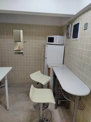 a kitchen with white tables and chairs and a refrigerator at Friends Apartment Syngrou in Athens