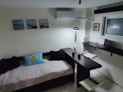 a bedroom with a desk and a bed and a desk and a laptop at Friends Apartment Syngrou in Athens