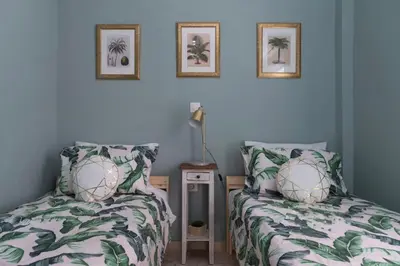 two beds in a bedroom with blue walls at Artistic apt in vibrant Gazi with large terrace by GHH in Athens