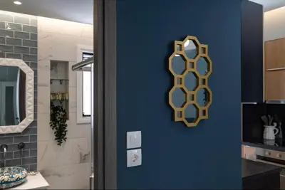 a bathroom with a mirror on a blue wall at Artistic apt in vibrant Gazi with large terrace by GHH in Athens