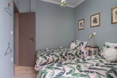 a bedroom with a bed with a green and white comforter at Artistic apt in vibrant Gazi with large terrace by GHH in Athens