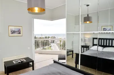 a bedroom with a bed and a balcony at Athens Edem Beach Penthouse, panoramic sea view in Athens