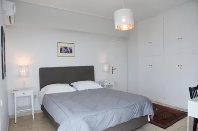 a bedroom with a large bed with two night stands at Athens Edem Beach Penthouse, panoramic sea view in Athens