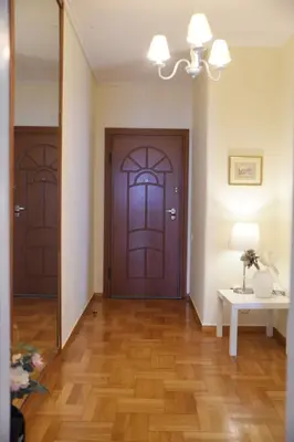 a hallway with two doors and a wooden floor at Athens Edem Beach Penthouse, panoramic sea view in Athens
