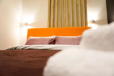 a bedroom with a bed with an orange headboard and pillows at Boho Privet Flat in Athens in Athens
