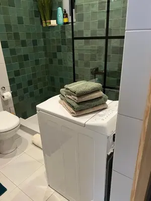 a bathroom with a toilet and towels on top of a refrigerator at Boho Privet Flat in Athens in Athens