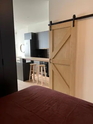 a sliding barn door in a room with a kitchen at Boho Privet Flat in Athens in Athens